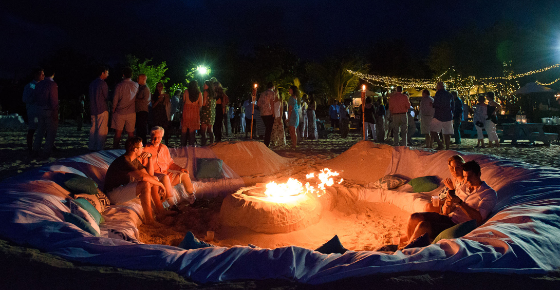 Beach bonfire with a carved sand lounge around it for guests to sit and relax